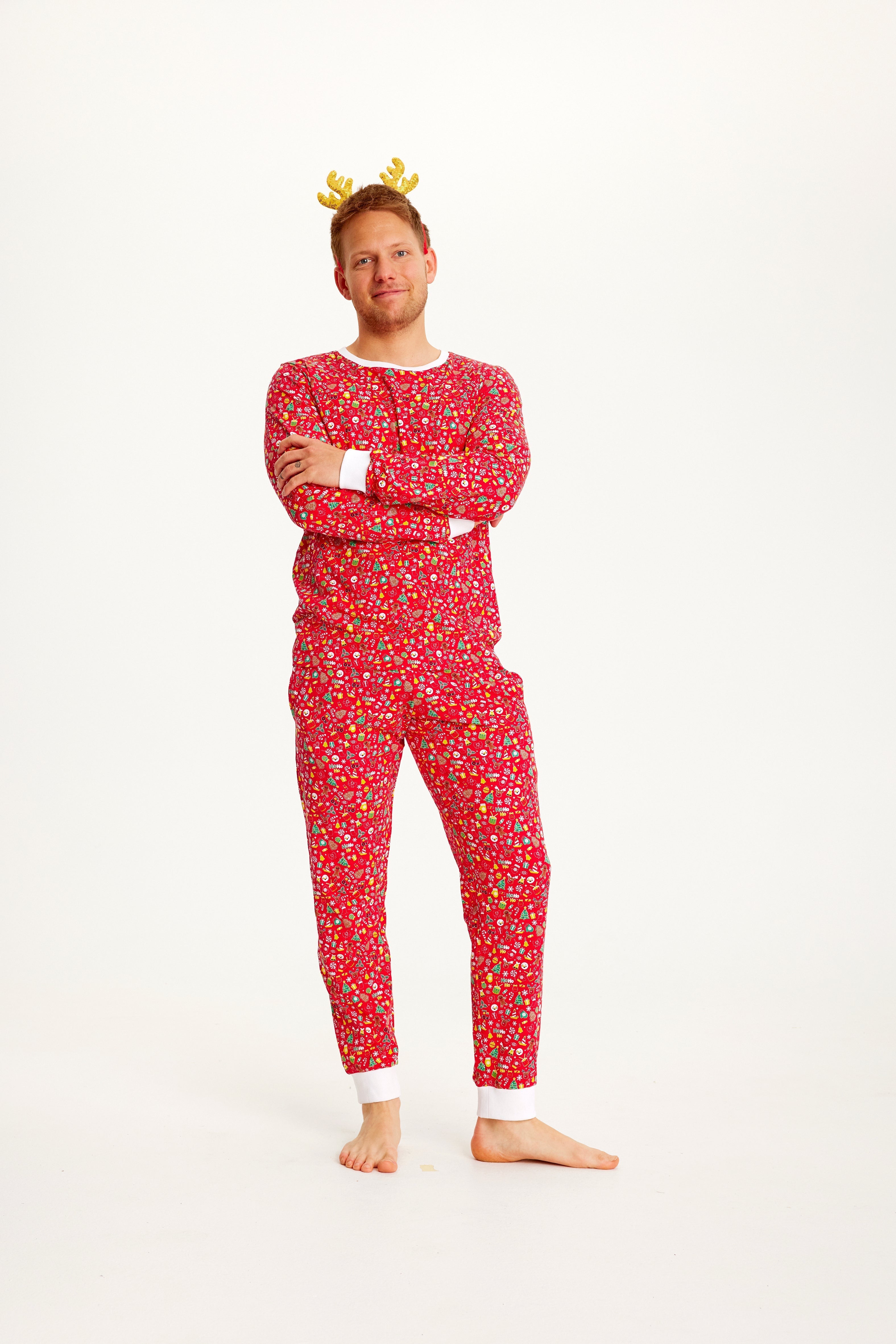 Een man met gekruiste armen in een rode kerstpyjama.
